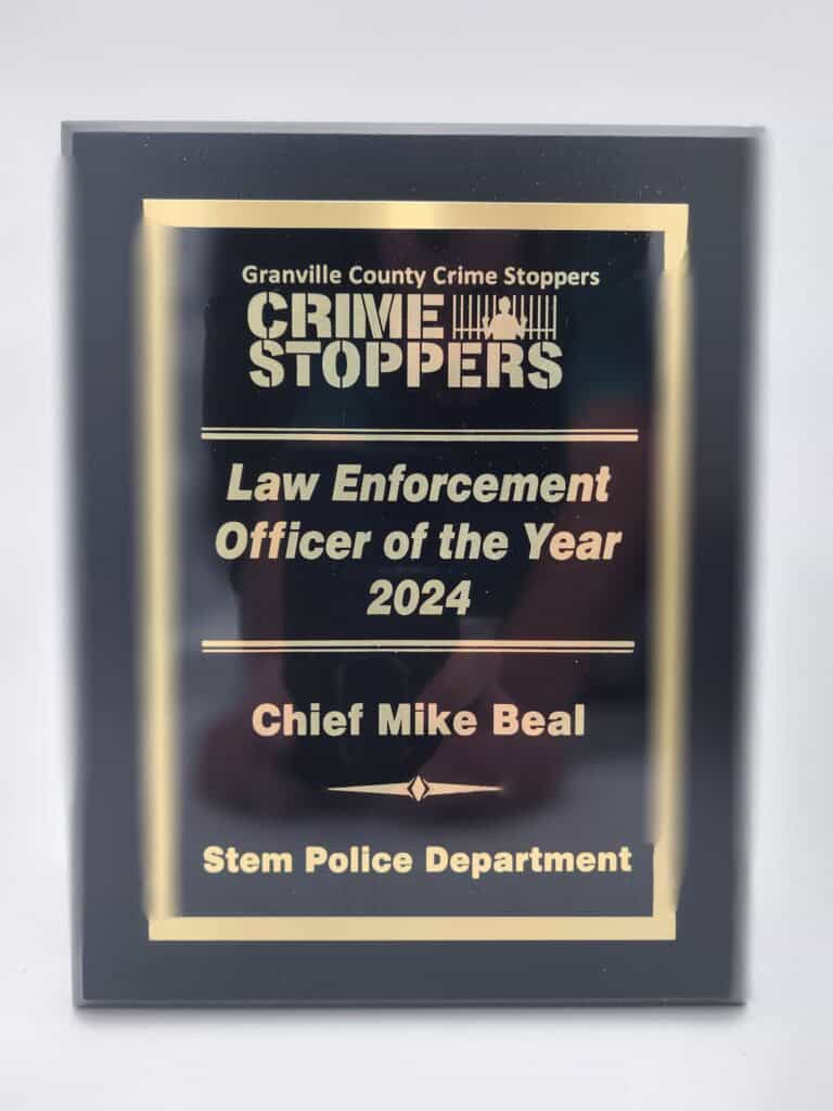 A plaque recognizing Chief Mike Beal as the Law Enforcement Officer of the Year 2024, awarded by Granville County Crime Stoppers to the Stem Police Department.