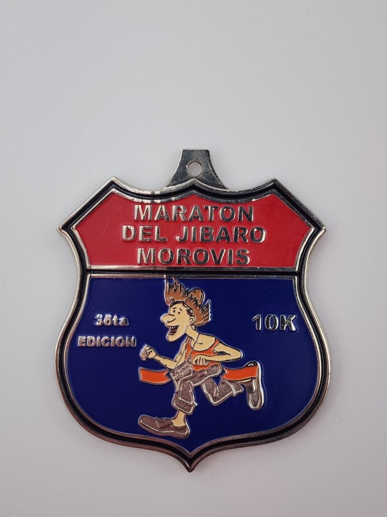 A custom medal featuring a red and blue design with the text 'Maraton Del Jibaro Morovis' and '36ta Edicion 10K'. It also includes an illustration of a runner.