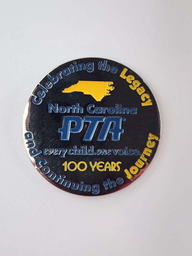 A commemorative circular badge for the North Carolina PTA, featuring the outline of the state in yellow, with blue and yellow text reading "Celebrating the Legacy, Every Child. One Voice, 100 Years, and Continuing the Journey."