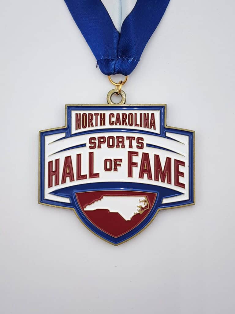 A custom medal with the inscription "North Carolina Sports Hall of Fame" featuring a map outline of North Carolina, attached to a blue ribbon.