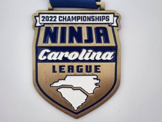 A custom medal for the 2022 Championships of the Ninja Carolina League, featuring a design with the text and an outline of North and South Carolina on a blue ribbon.