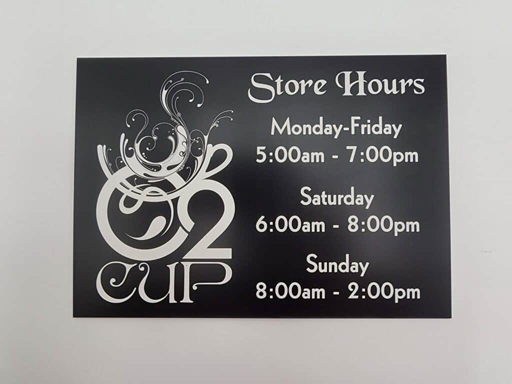 A store hours sign for "O2 Cup" showing business hours: Monday-Friday 5:00am - 7:00pm, Saturday 6:00am - 8:00pm, and Sunday 8:00am - 2:00pm.