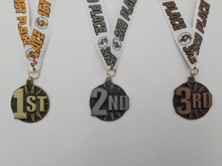 Three sports medals with ribbons labeled "1st Place," "2nd Place," and "3rd Place," featuring gold, silver, and bronze finishes.