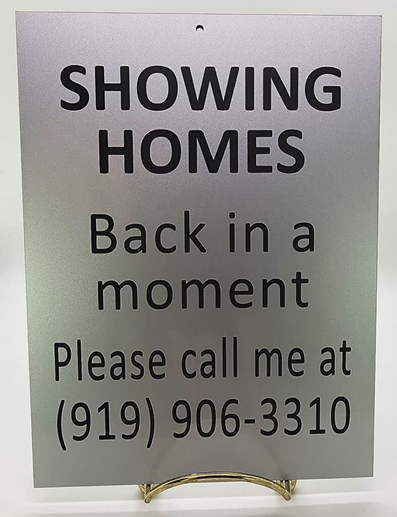 A metal sign reads: "SHOWING HOMES. Back in a moment. Please call me at (919) 906-3310."