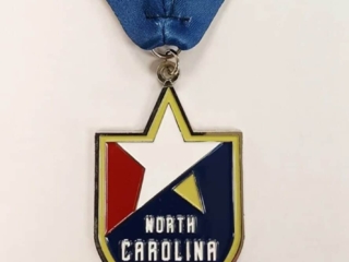Custom medal featuring the North Carolina FC logo with a star design, attached to a blue and red ribbon.