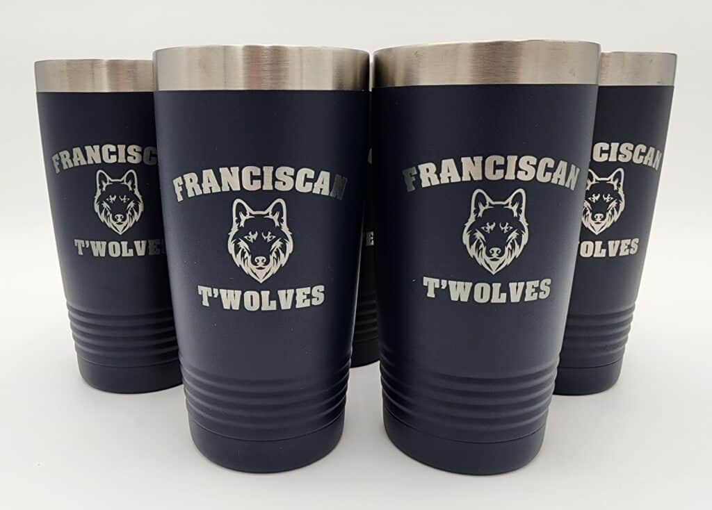 Four dark blue tumblers with silver lids, each featuring the logo and text "Franciscan T'Wolves" along with a wolf's head graphic.